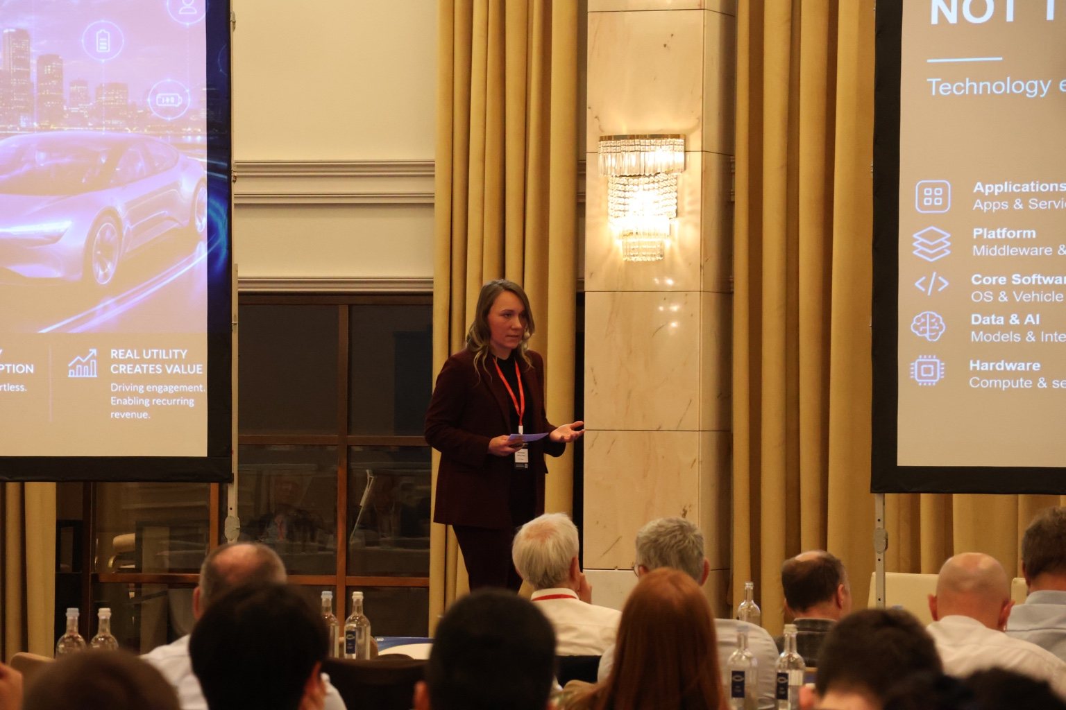 Janine Bubner presenting between two keynote screens at the European AI and SDV Summit